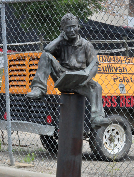 man reading a book sculpture